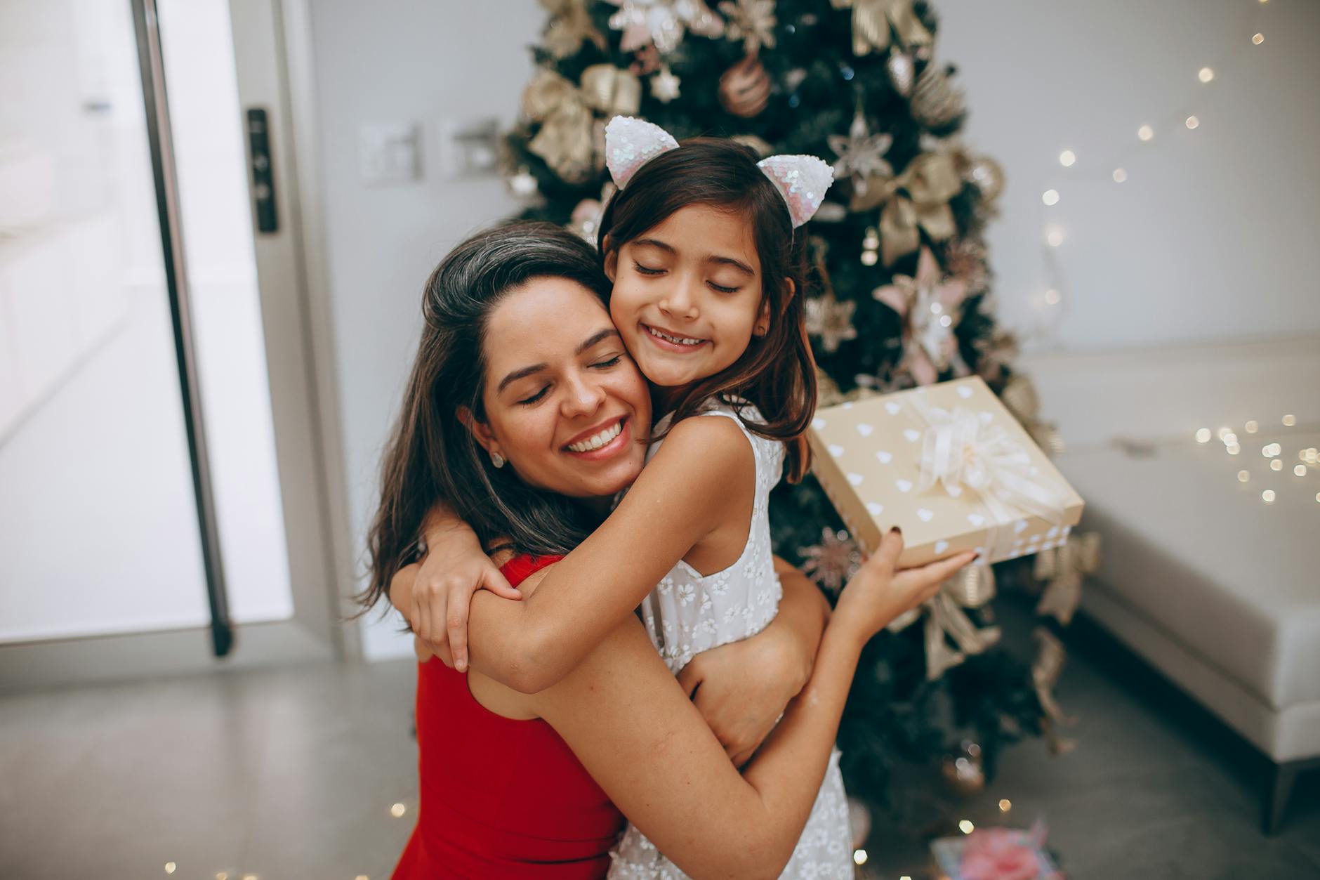 https://www.pexels.com/photo/mother-and-daughter-embracing-by-the-christmas-tree-27086644/